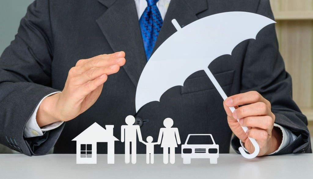 Businessman shielding family, home and car with umbrella – life insurance Toronto