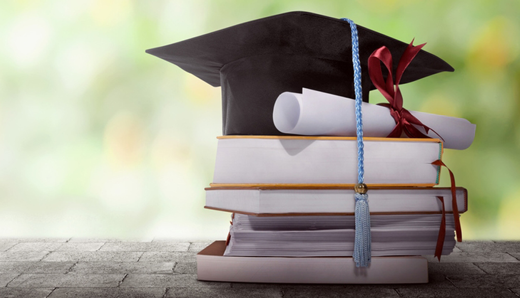 Graduation cap and diploma on stacked books – RESP education savings Canada
