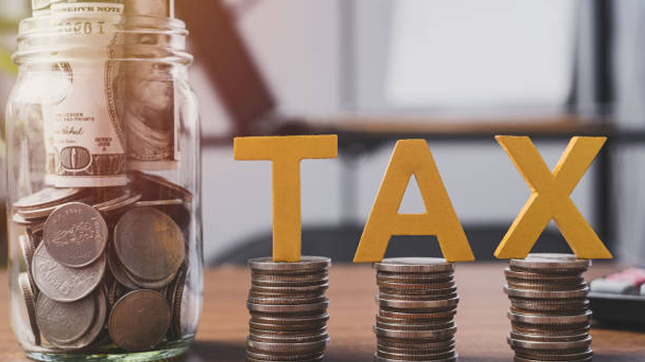 Coin stacks with TAX letters and savings jar – best TFSA account Canada